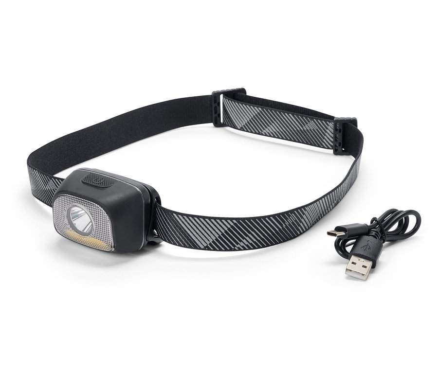 Černá čelovka s šedo-bílým vzorovaným páskem a nabíjecím kabelem USB.