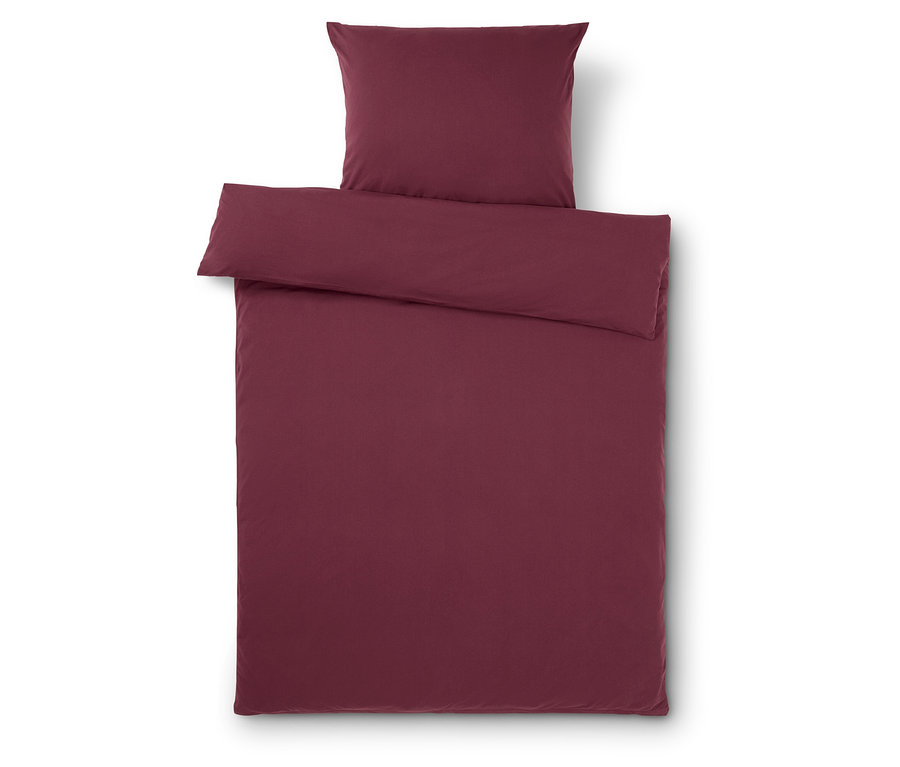 Vínové ložní prádlo s povlakem na polštář a přikrývku na bílém pozadí.