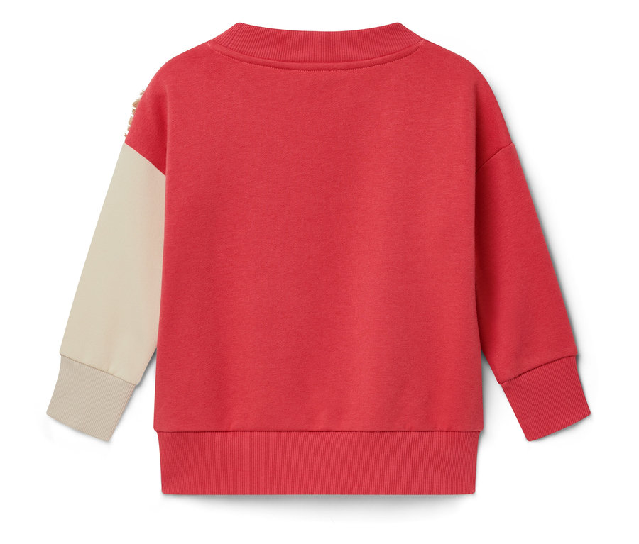 Zadní pohled na červenou mikinu s krémovým rukávem.