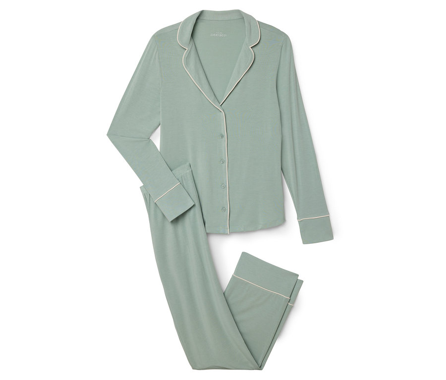 Zelené pyžamo s bílým lemováním leží na bílém pozadí.