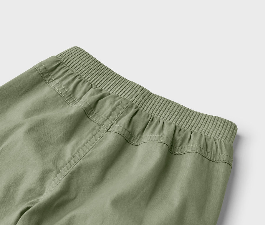 Detailní záběr na zadní část olivově zelených kalhot s elastickým pasem.