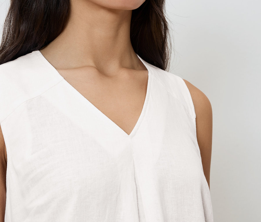 Detailní záběr ženy v bílém tílku s výstřihem do V.