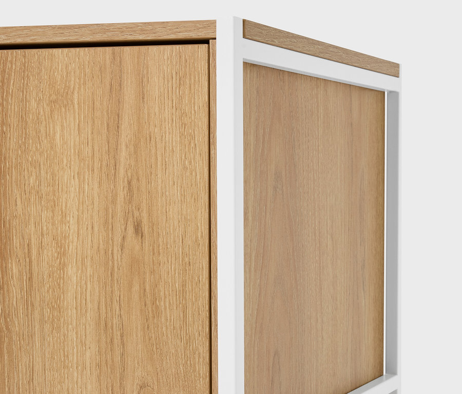 Detail dvou světle hnědých dřevěných skříněk s bílými rámy.