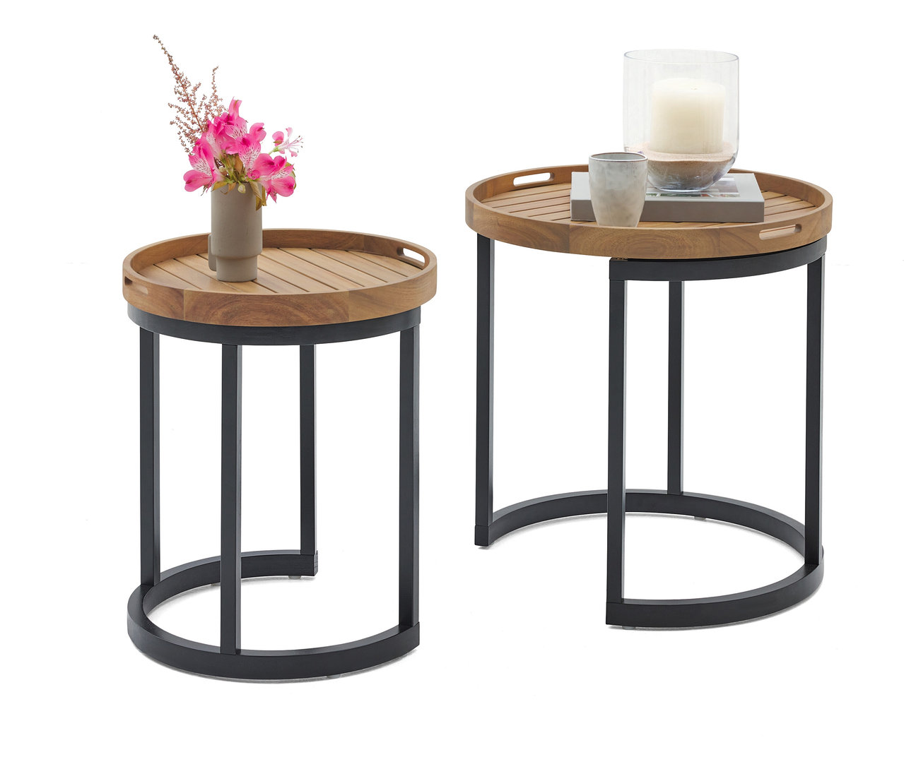 Dva kulaté odkládací stolky s dřevěnou deskou a černým kovovým rámem. Na jednom stolku je váza s růžovými květinami, na druhém svíčka ve skleněné nádobě a šálek.