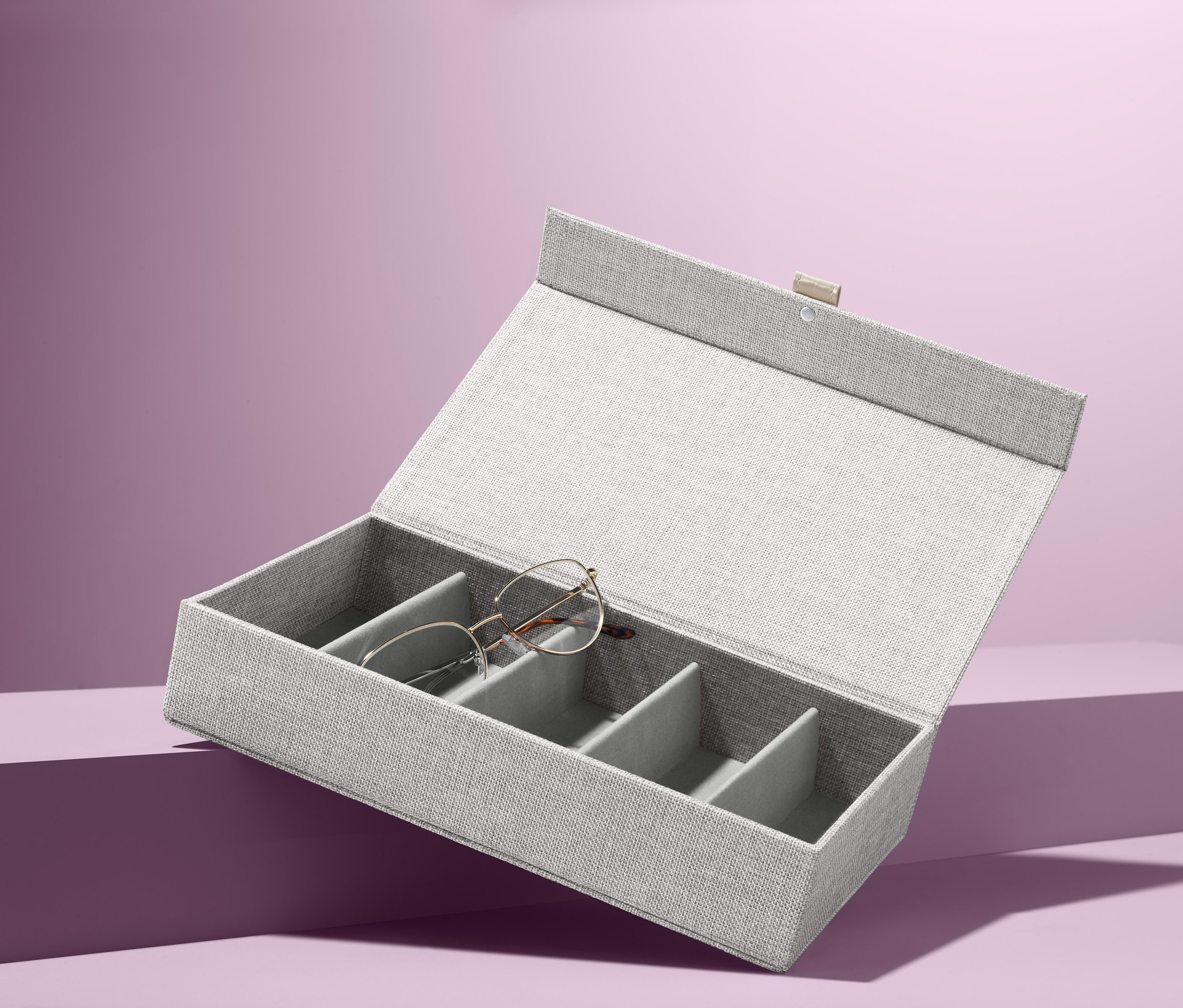 Otevřený šedý box na brýle s jedněmi brýlemi uvnitř.