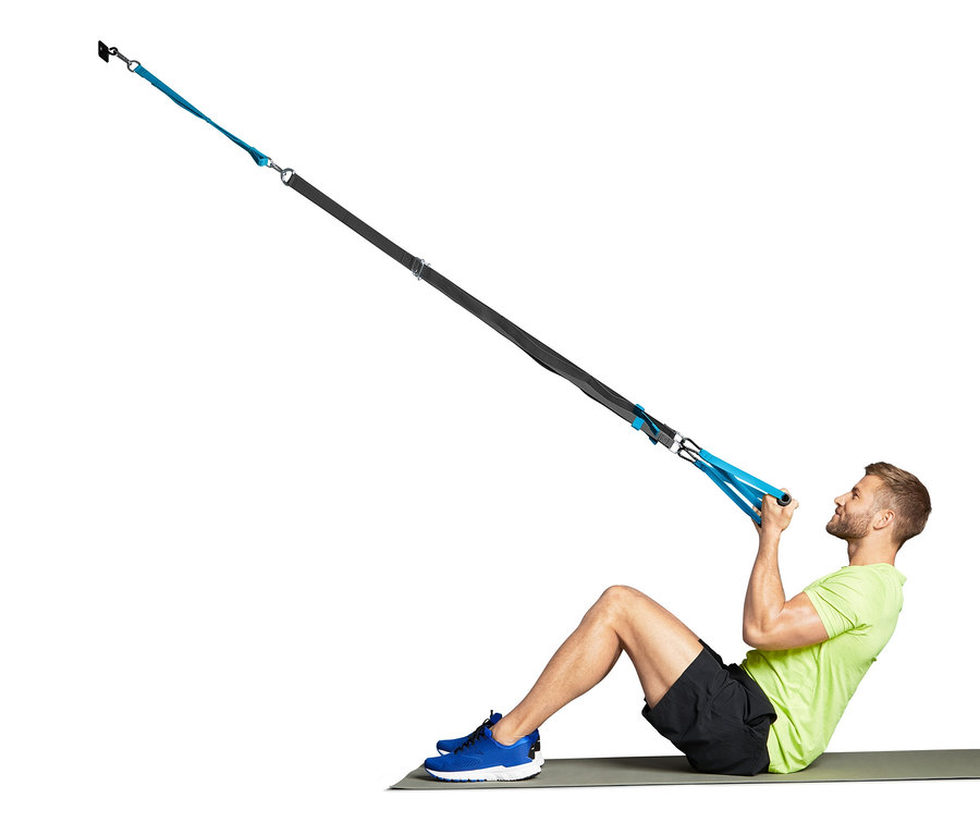 Muž cvičí s závěsným posilovacím systémem.