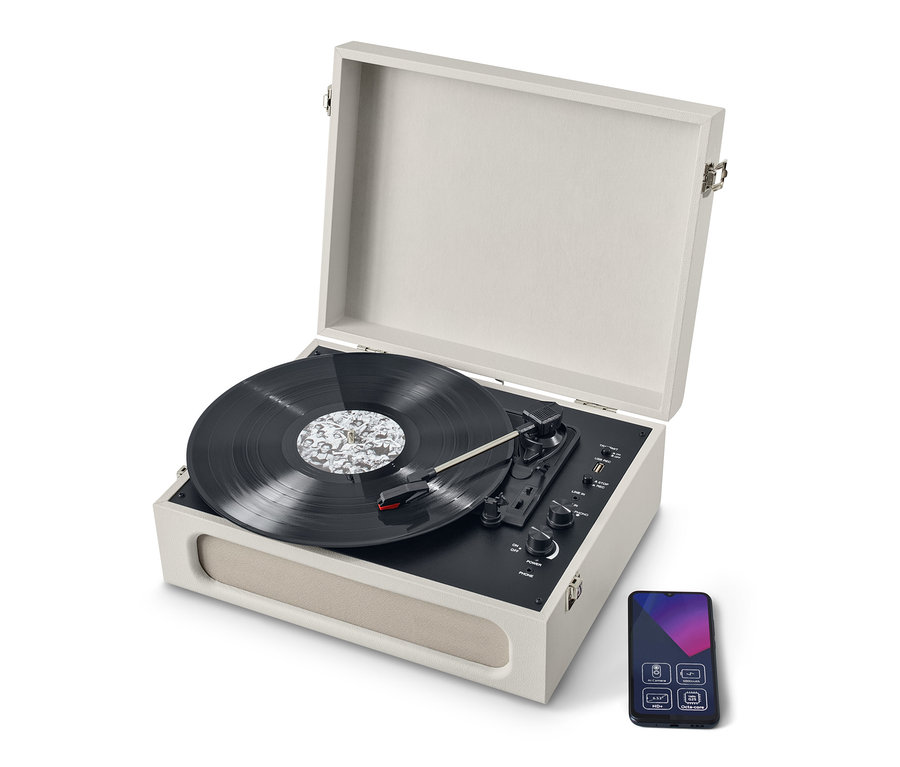 Béžový přenosný gramofon v retro stylu s funkcí Bluetooth® s otevřeným víkem a deskou. Vedle gramofonu je smartphone.