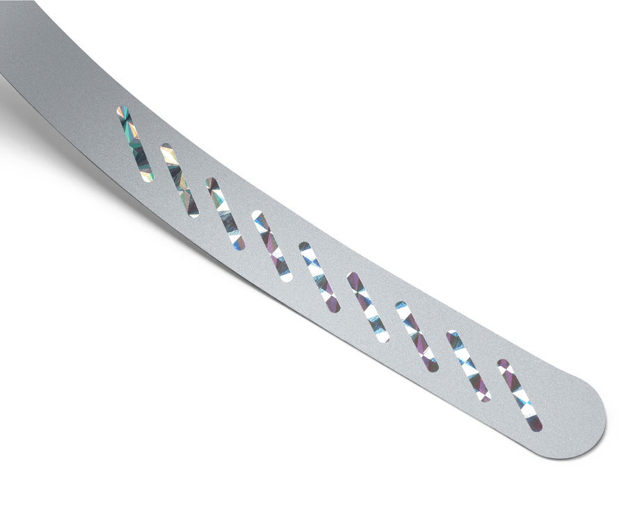 Stříbrný odpuzovač much s otvory na bílém pozadí.