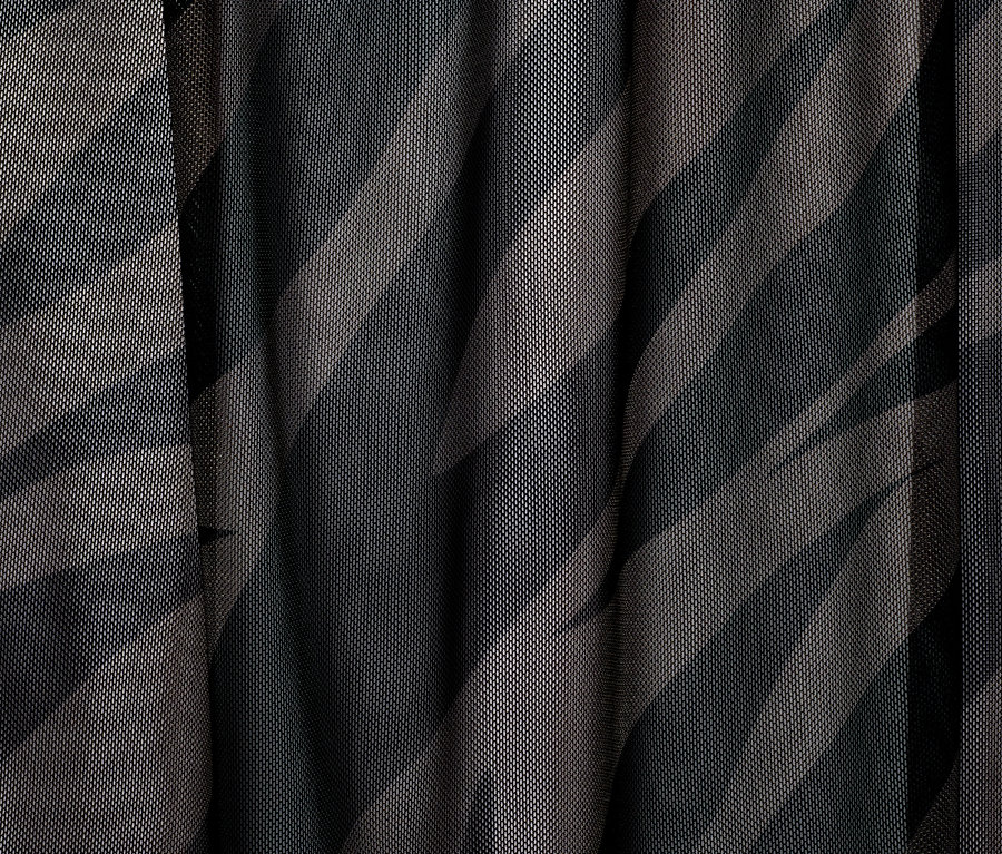 Detailní záběr síťovaných šatů s potiskem.