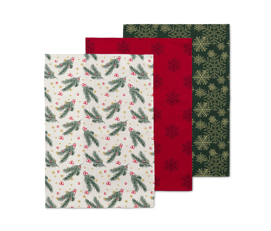 Tři utěrky: jedna s motivem jehličí, druhá červená se sněhovými vločkami, třetí zelená se zlatými sněhovými vločkami.