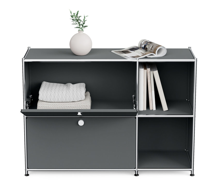 Šedá kovová odkládací skříňka »CN3« se 2 výklopnými dvířky. Na horní polici váza, knihy a časopis.