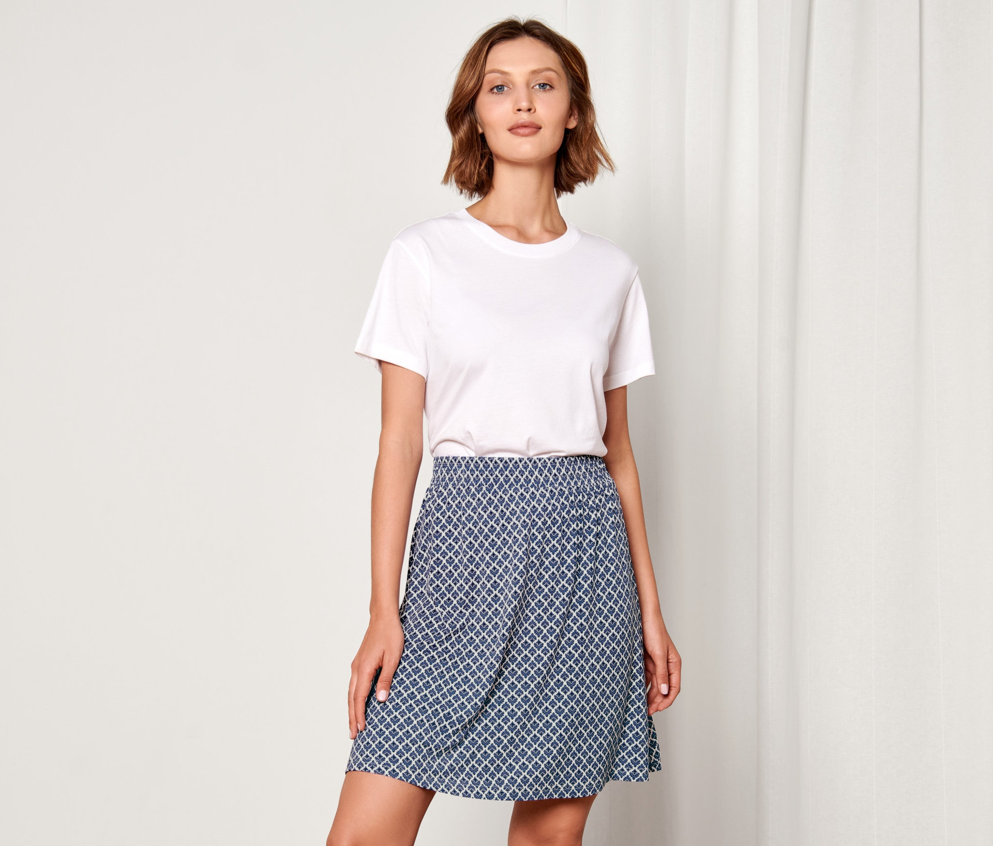 Žena pózuje na sobě s potiskem žerzejové sukně.