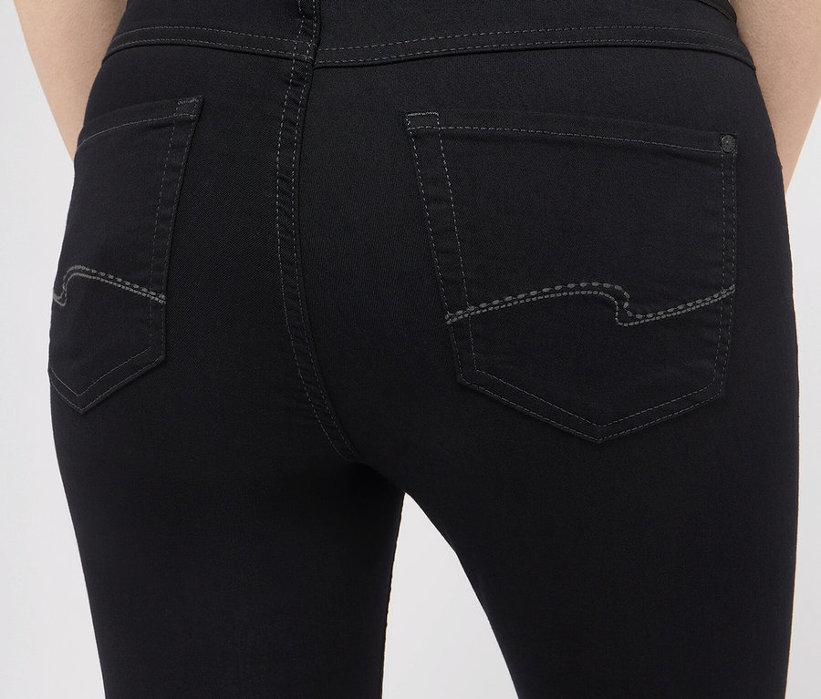Detail zadní části dámských černých džínů.