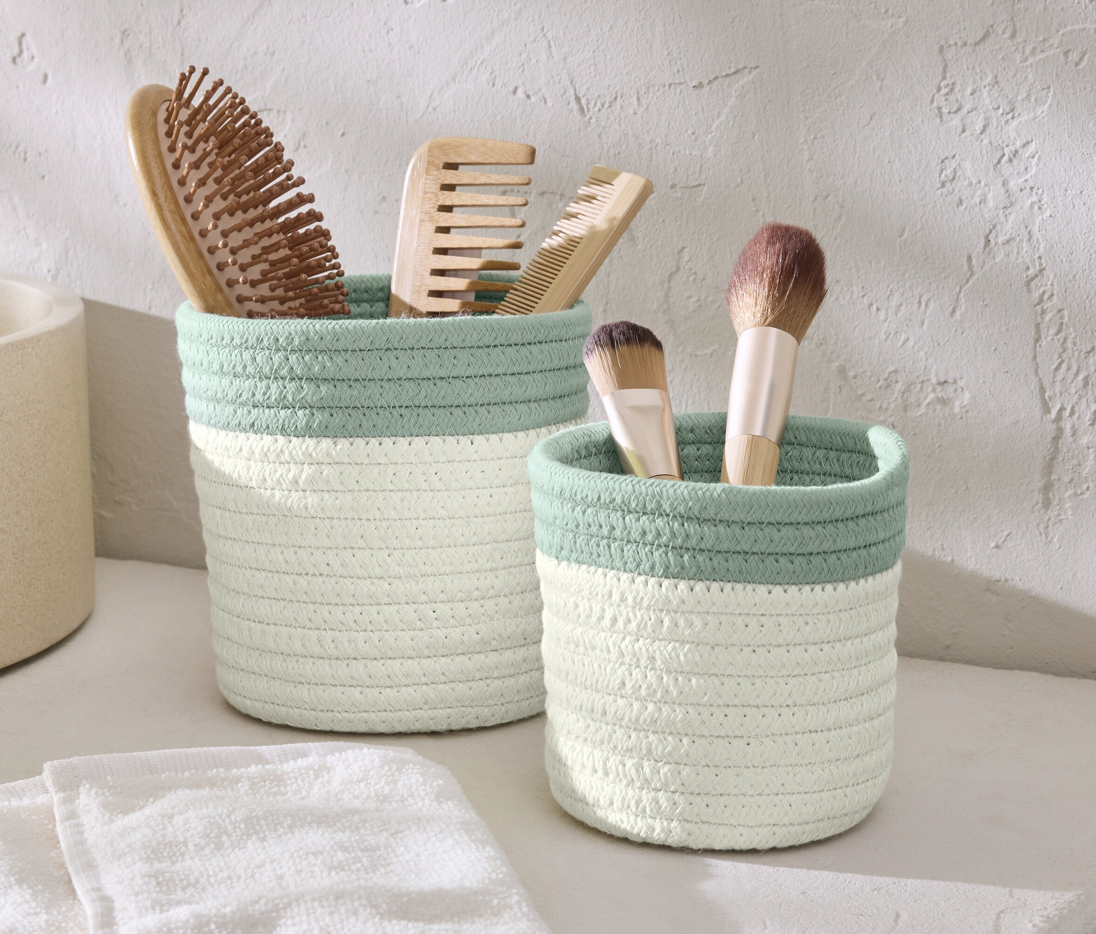Dva úložné košíky s hřebeny a štětci na make-up.