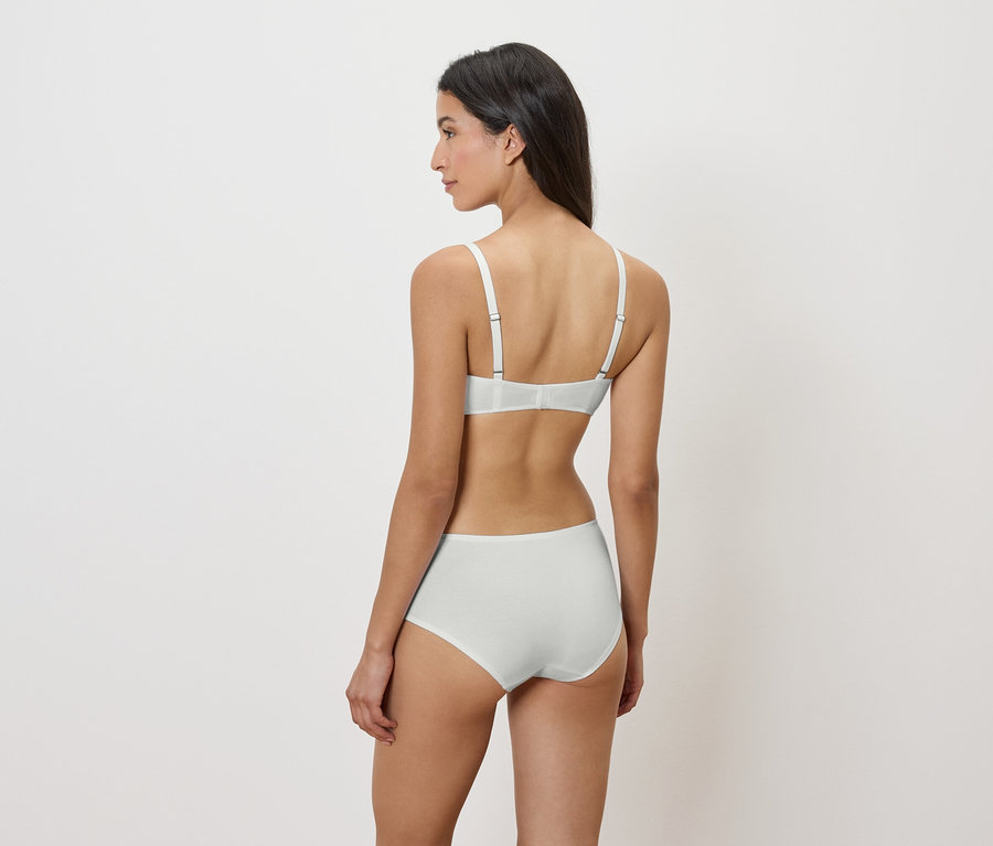 Žena zády, na sobě bílou podprsenku a kalhotky.