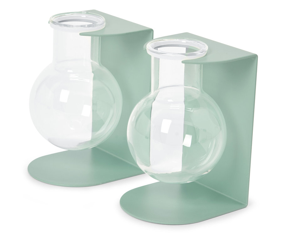 Dvě skleněné baňky v pastelově zelených kovových držácích.