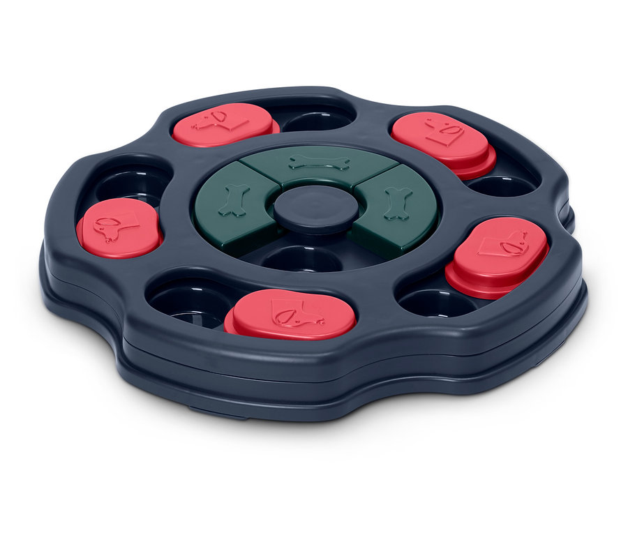 Interaktivní hračka pro psy s otočným mechanismem, červenými krytkami a zelenými kostičkami.