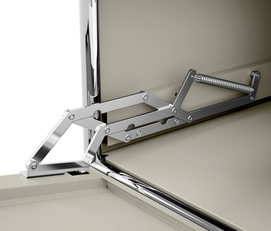 Detail chromovaného mechanismu pantu s pružinou u béžových dvířek.