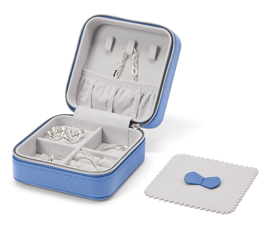 Otevřená modrá šperkovnice se stříbrnými šperky a leštícím hadříkem.