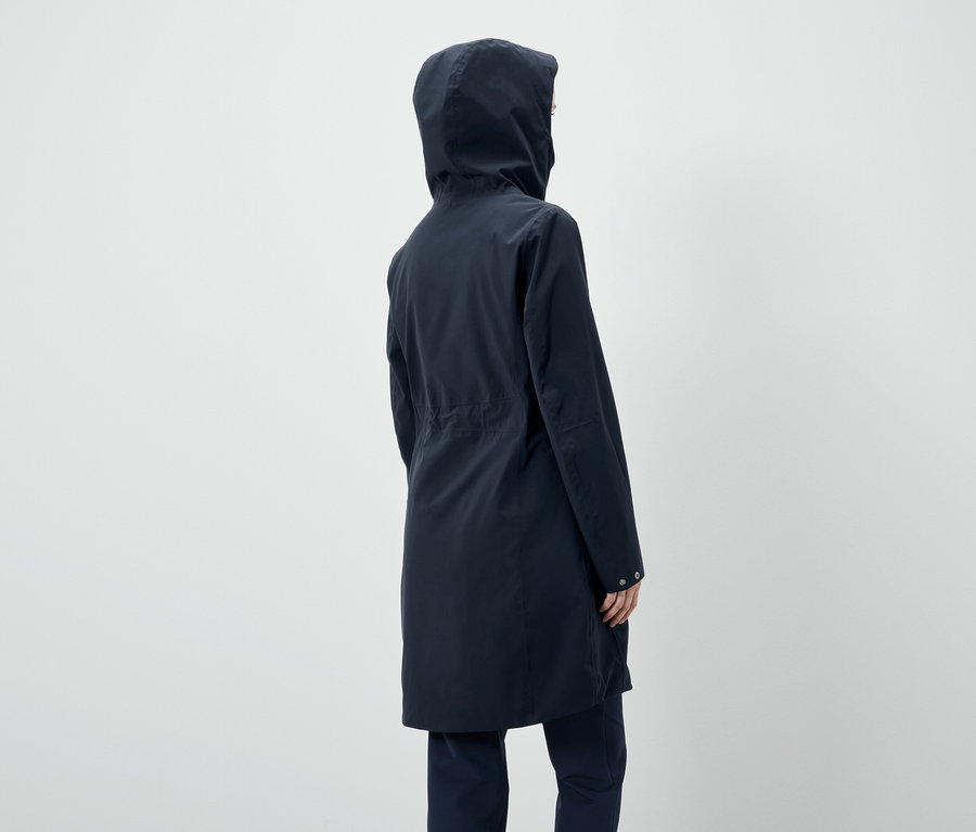 Zezadu pohled na osobu v tmavě modré bundě s kapucí.