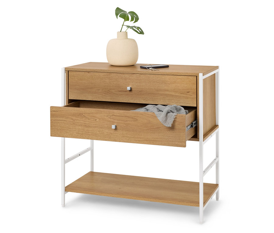 Komoda se dvěma zásuvkami, horní zavřená a spodní mírně otevřená, nahoře váza s rostlinou, telefon a klíč.