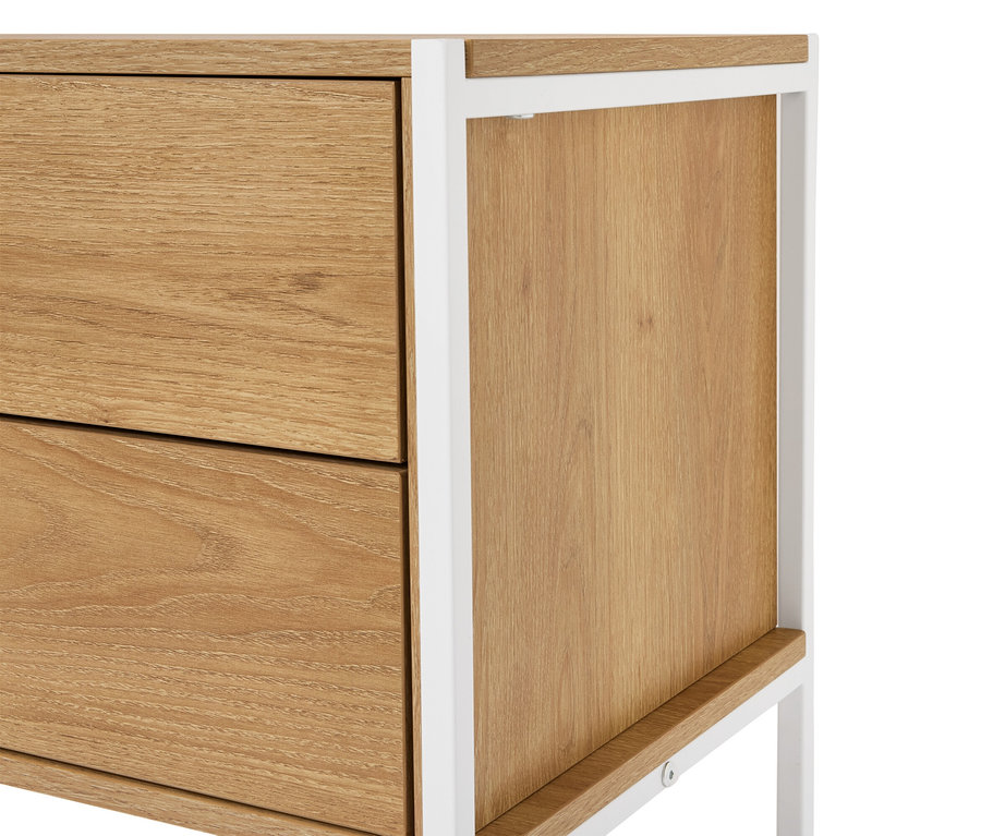 Detailní záběr na dřevěnou skříňku se dvěma zásuvkami a bílým kovovým rámem.