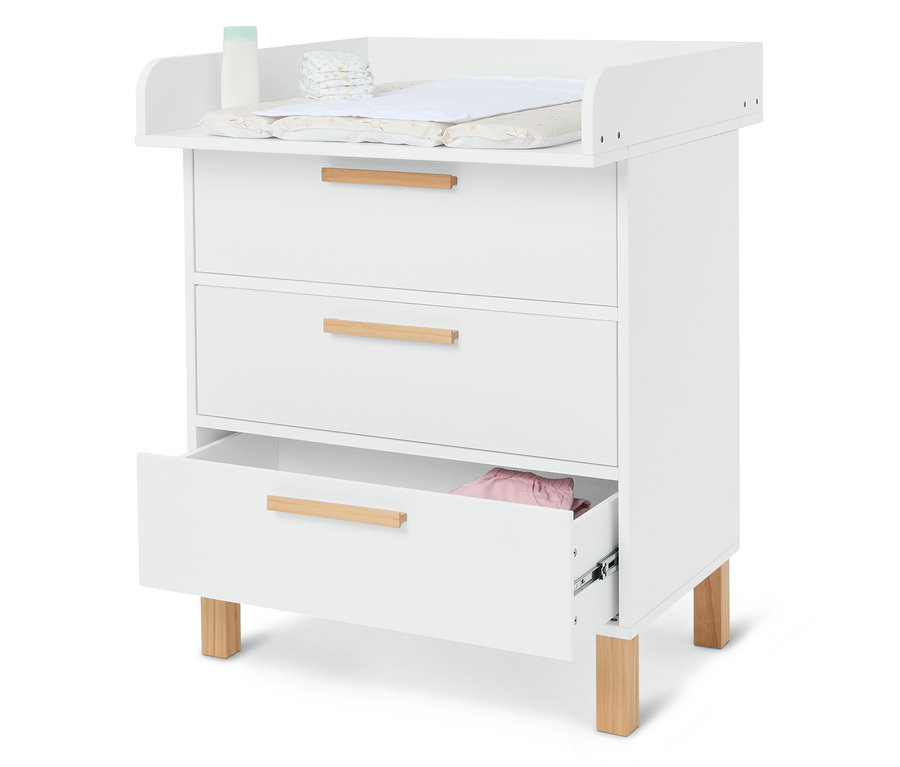 Bílá přebalovací komoda se třemi zásuvkami, plenami, krémem a přebalovací podložkou.