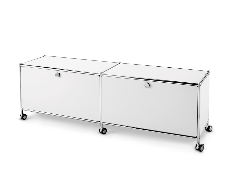 Dvě bílé nízké kovové skříňky »CN3« se 2 výklopnými dvířky.