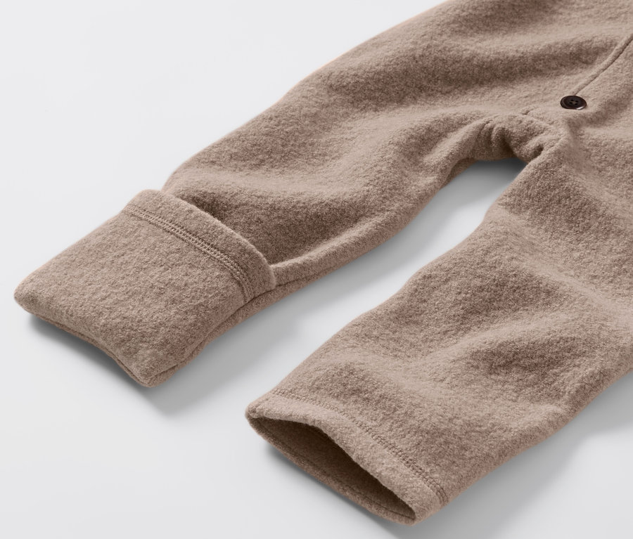 Detail hnědé merino kombinézy pro miminka.
