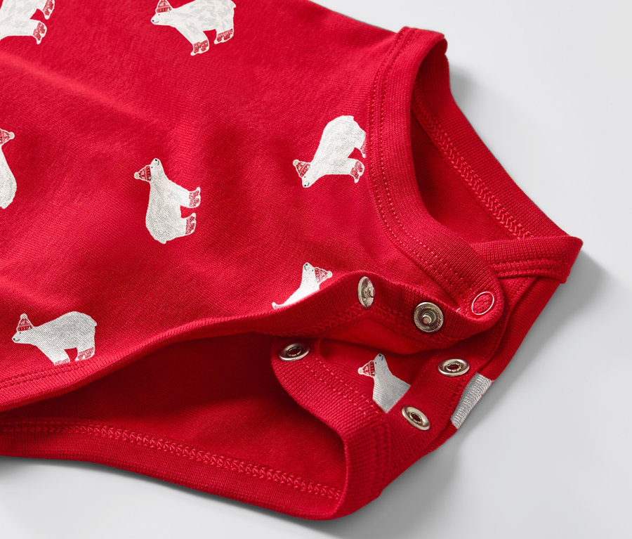 Detail červeného dětského body s dlouhým rukávem s potiskem ledních medvědů.