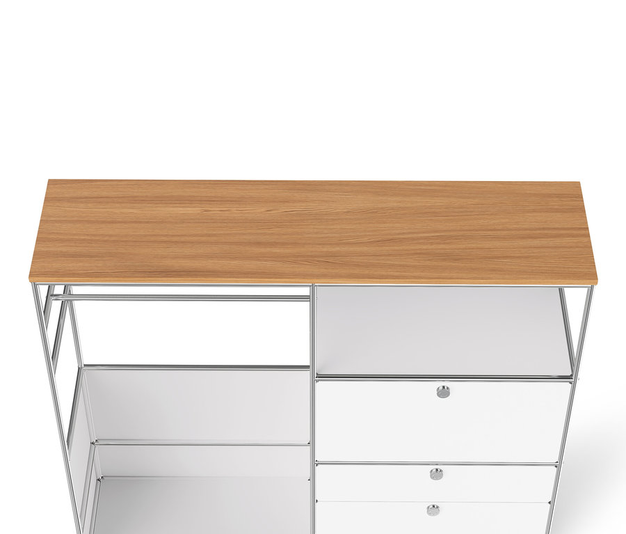 Detail bílé kovové skříně »CN3« s dřevěnou deskou, šatní tyčí, výklopnými dvířky a třemi zásuvkami.