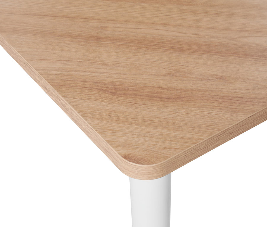 Detail rohu trojúhelníkového stolu s dřevěnou deskou a bílou nohou.