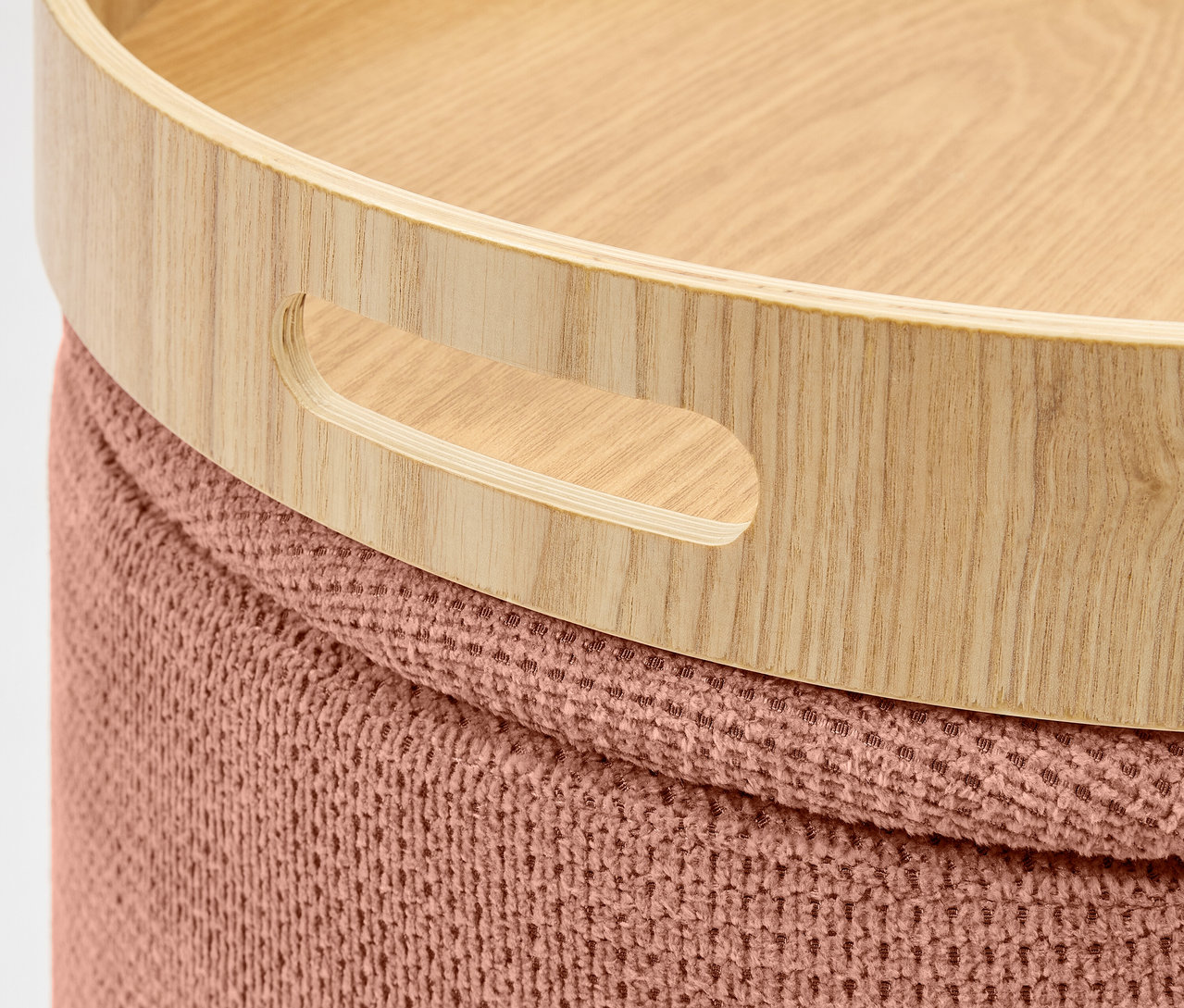 Detail dřevěného podnosu s držadly na pleteném taburetu.