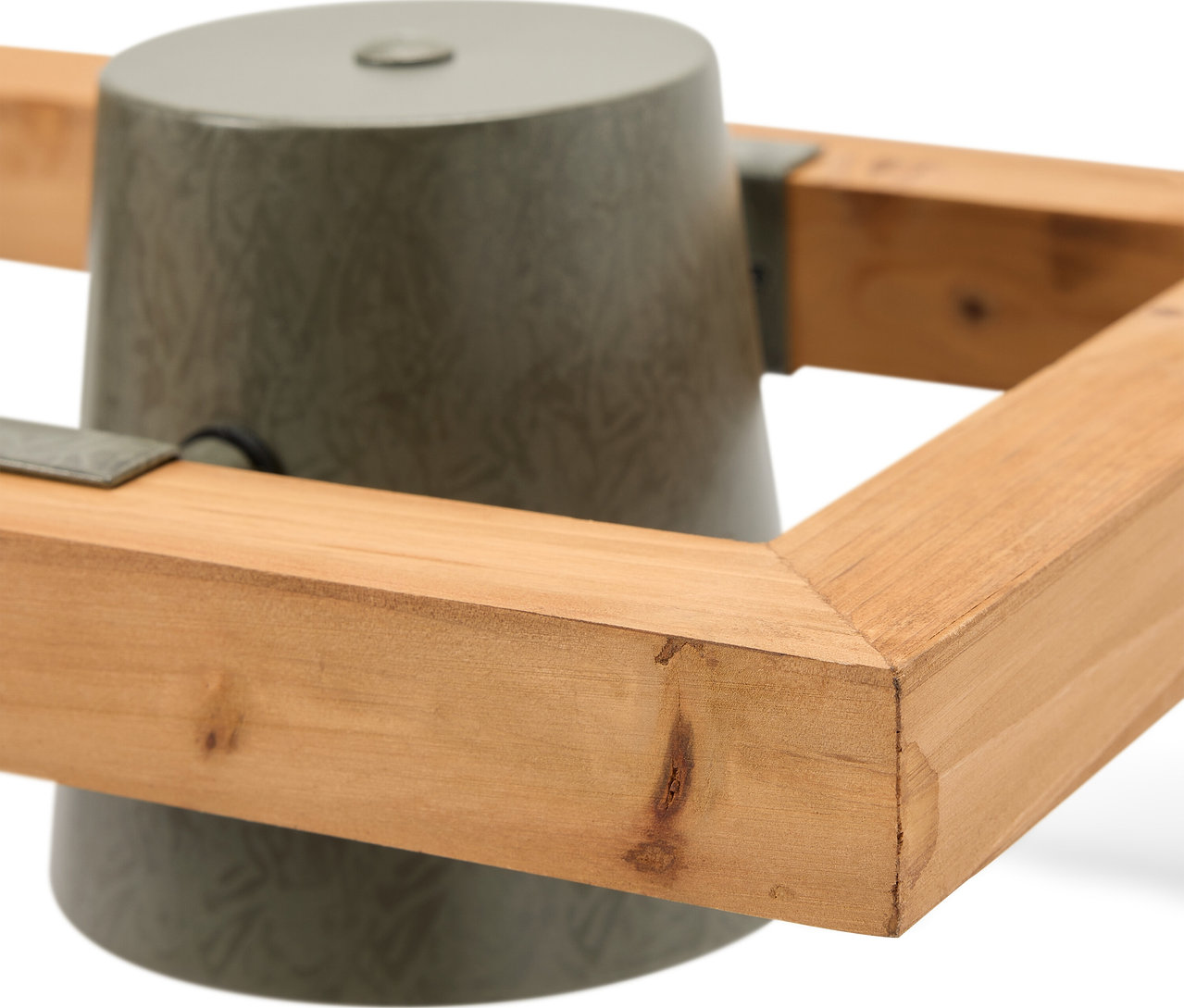 Detail šedého stojanu na vánoční stromek s dřevěným rámem.