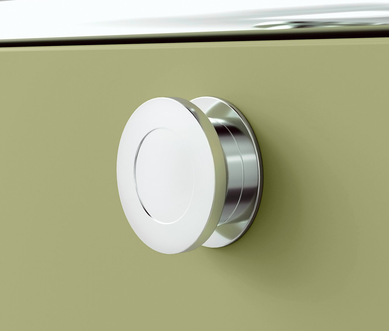 Detail chromové kulaté rukojeti na zelené skříňce.