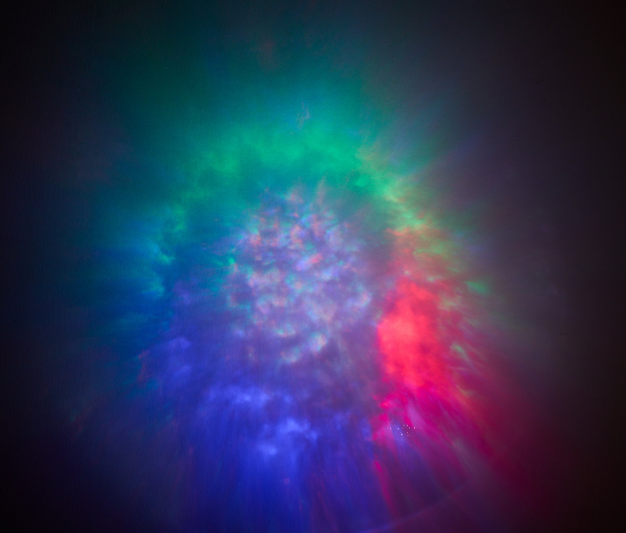 Abstraktní pozadí s rozmazanými světly v odstínech modré, zelené a červené.