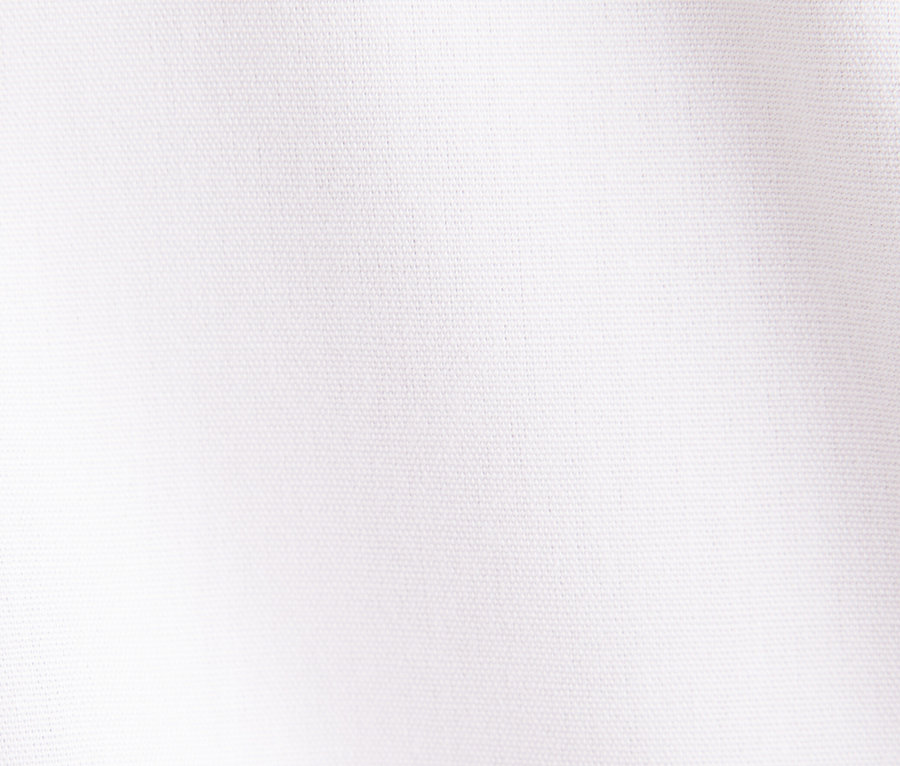 Detail bílé látky s jemnou texturou a mírným stínem.