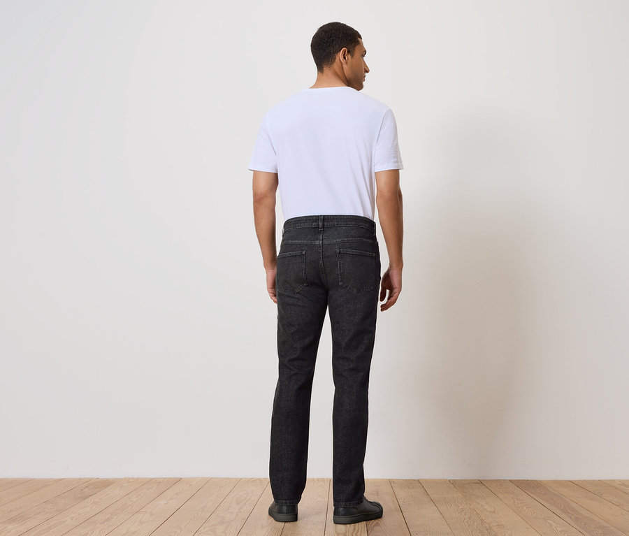 Muž zády k fotoaparátu má na sobě džíny a tričko.