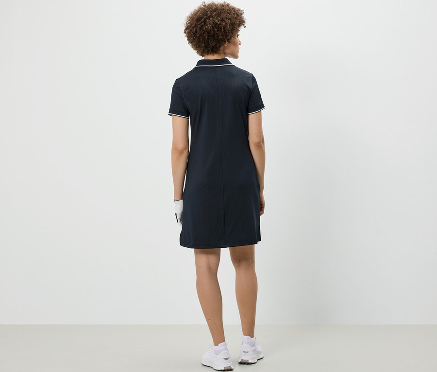 Žena stojí zády k fotoaparátu a má na sobě sportovní šaty.