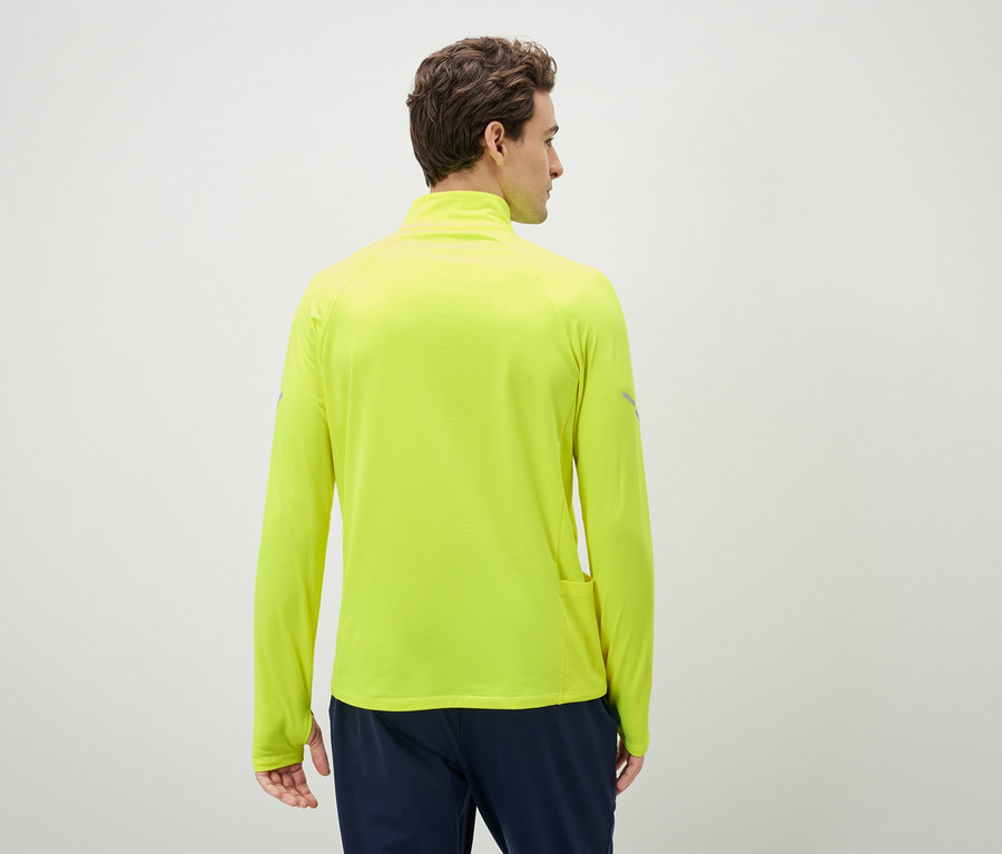 Muž zády k fotoaparátu má na sobě neonově žlutý sportovní top s dlouhým rukávem.