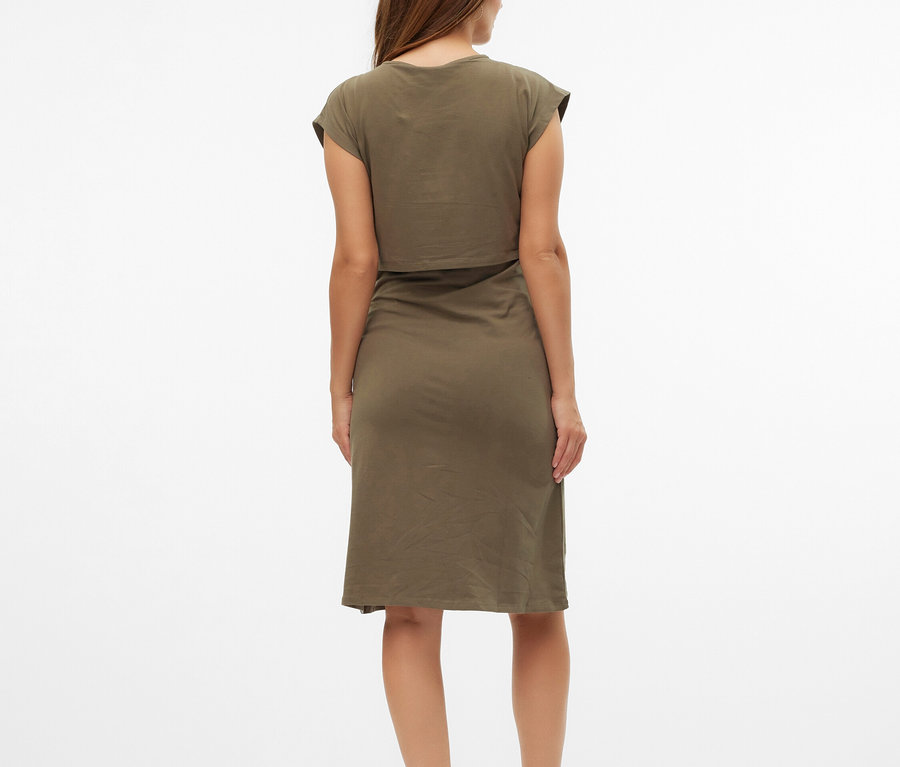 Žena zezadu v olivově zelených šatech a béžových sandálech.