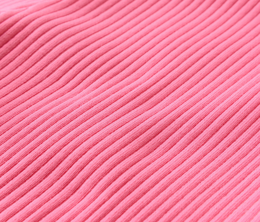 Detailní záběr na žebrovanou, růžovou látku.