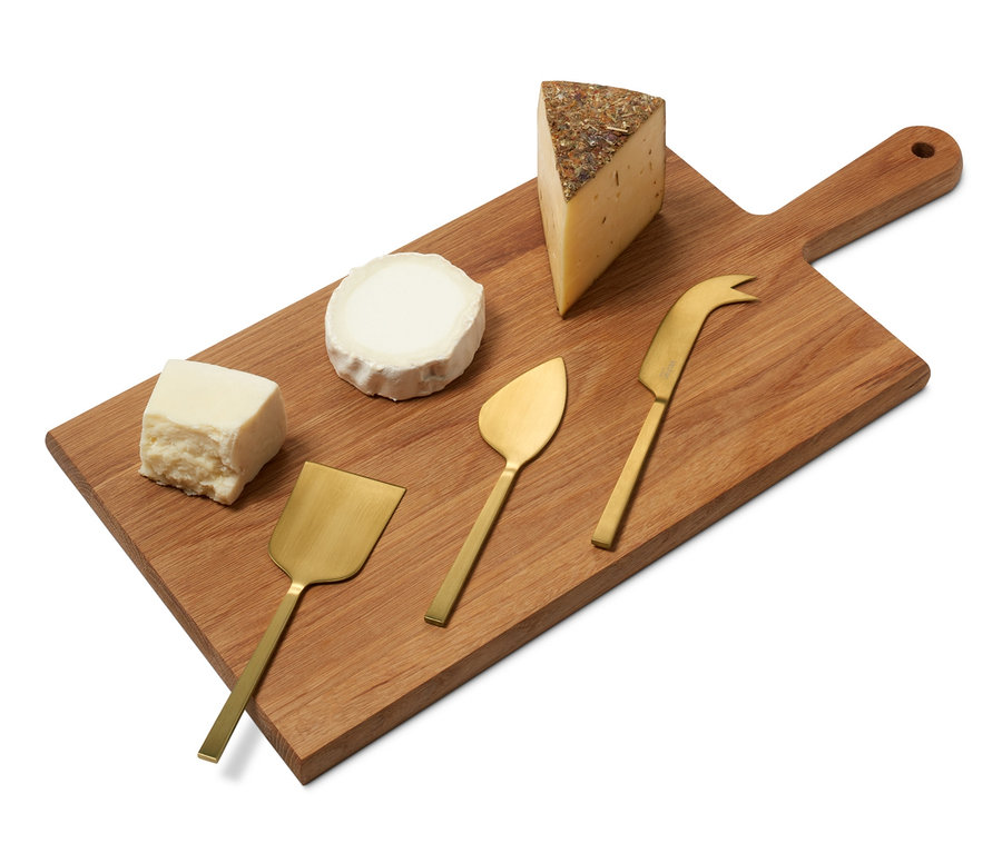 Dřevěné prkénko se sýry a sadou nožů na sýr.