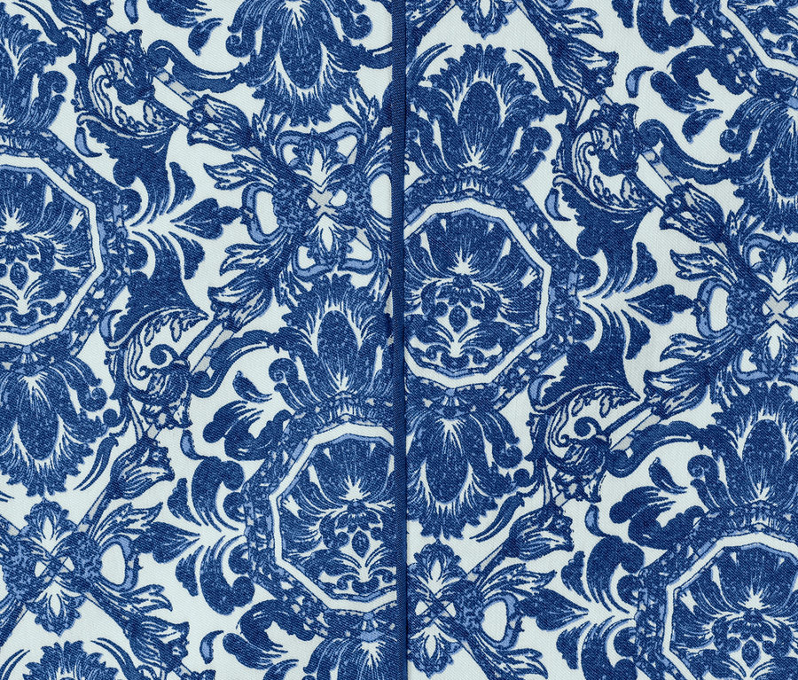 Detailní záběr modrých 3/4 strečových kalhot s potiskem.