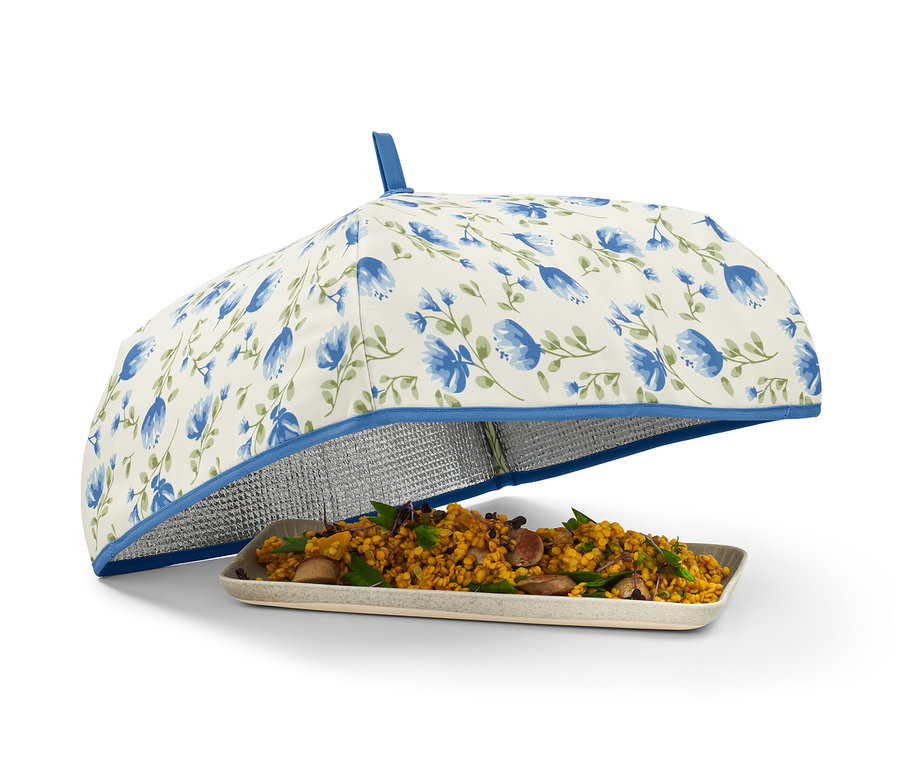 Jídlo na talíři zakryté termopoklopem s modrými květy.