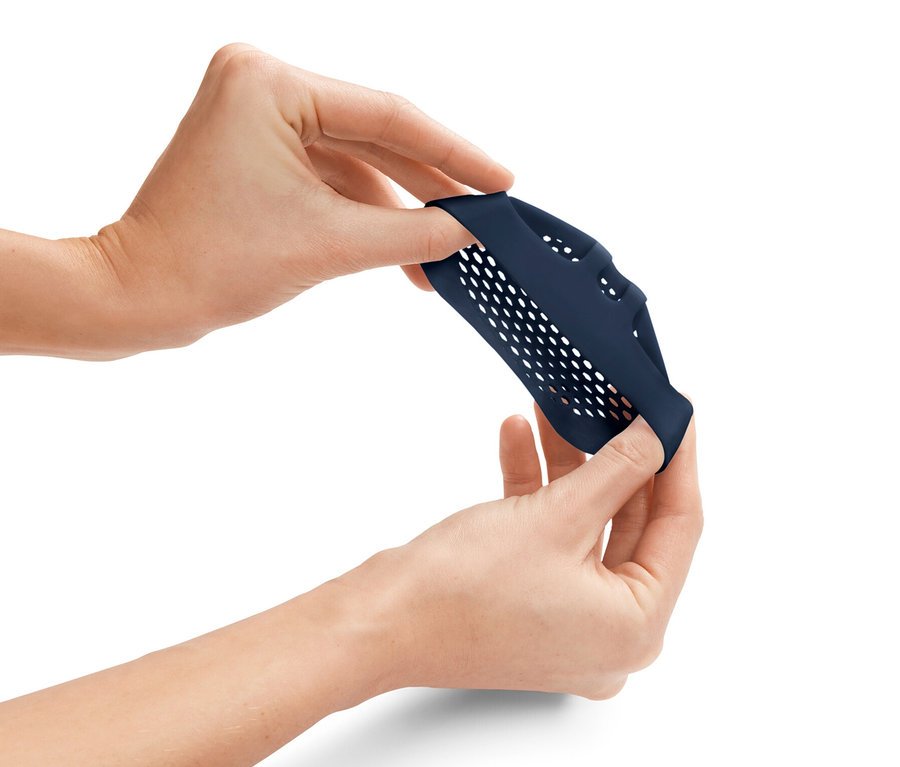 Žena roztahuje dva modré polštářky na bříška chodidel.