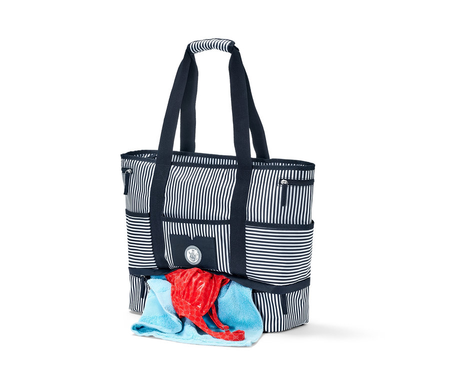 Pruhovaná plážová taška s modrými uchy a červeným a modrým ručníkem.
