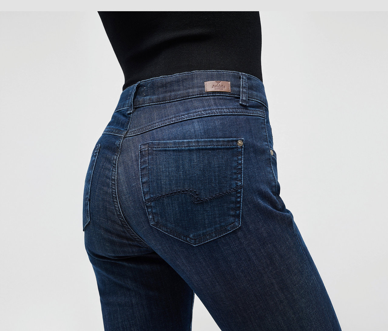 Detailní záběr na tmavě modré džíny Angels »Cici« slim fit na postavě.