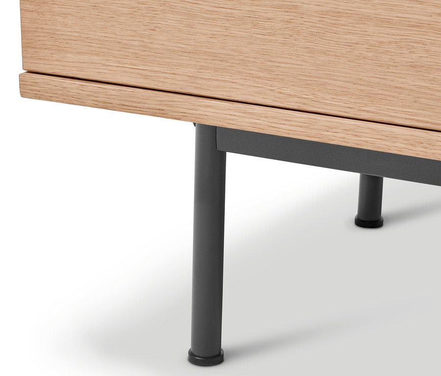 Detail komody »Finnsbo« s dřevěnou deskou a kovovýma nohama.