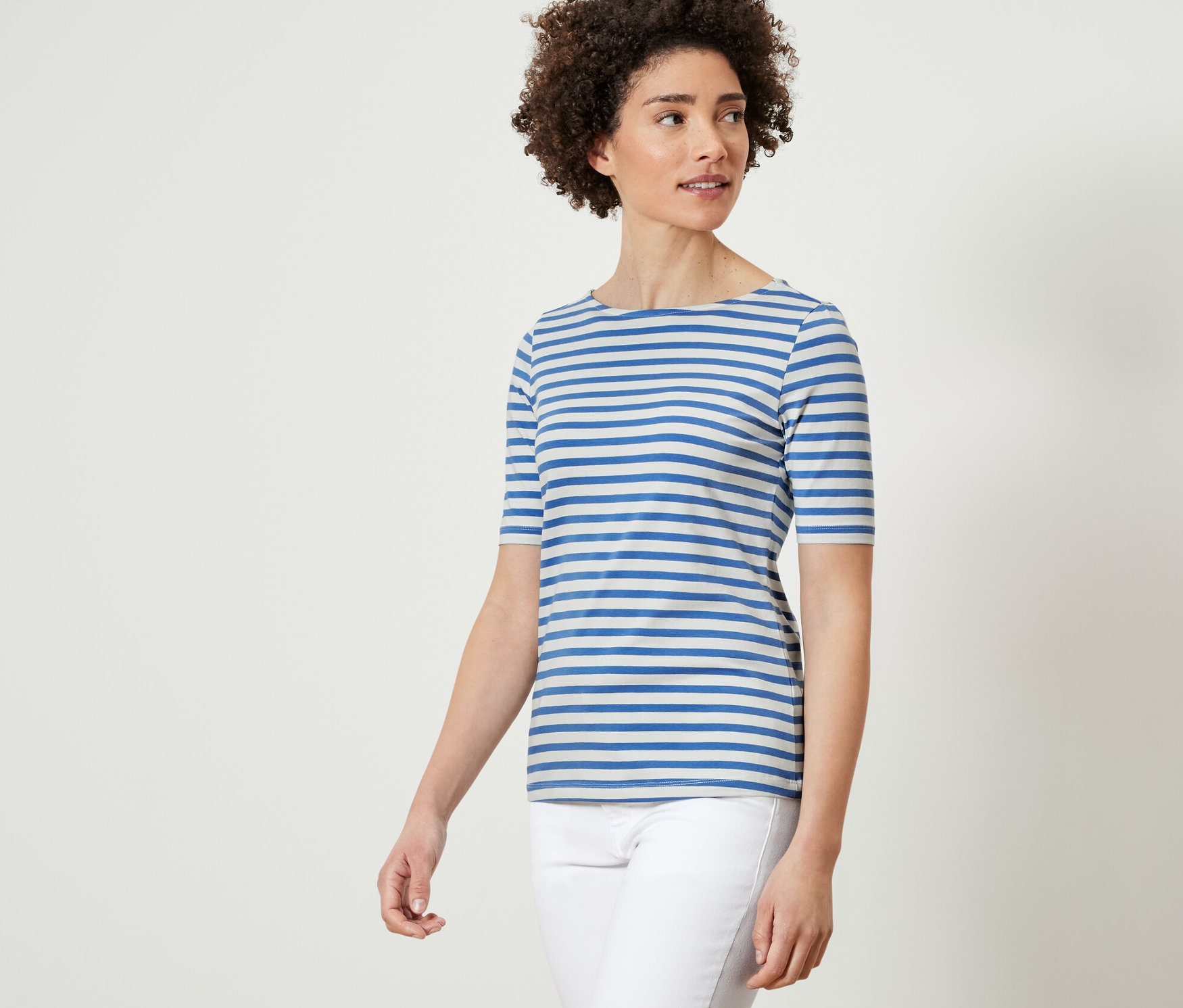 Žena má na sobě modrobílé pruhované tričko s polodlouhým rukávem.